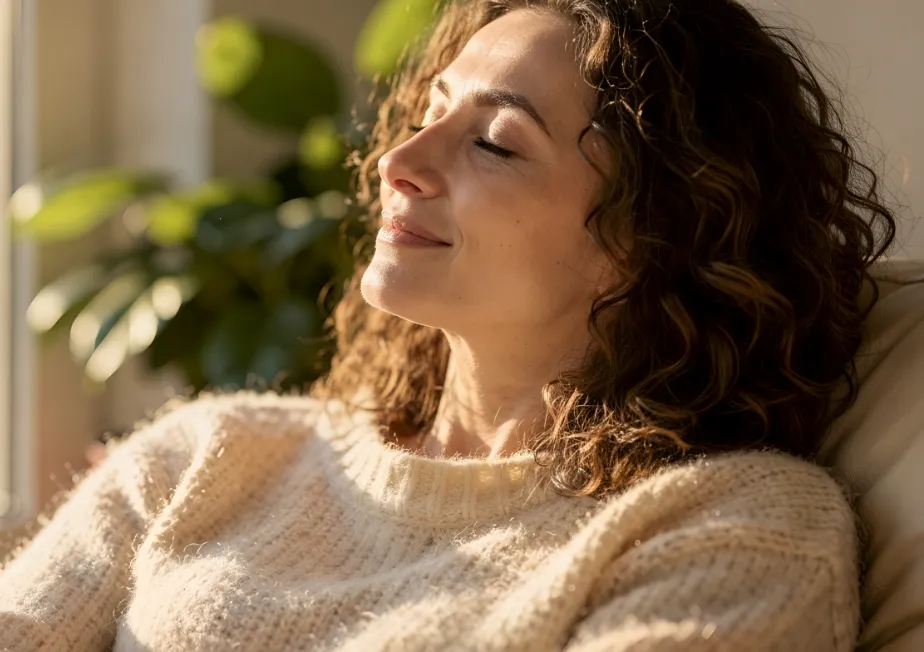 Femme apaisée souriant les yeux fermés au soleil